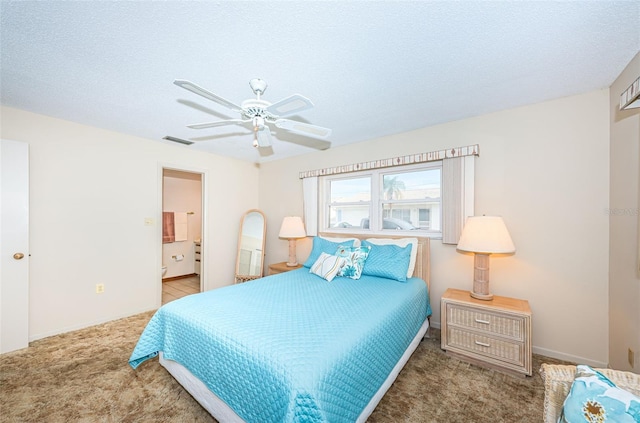 bedroom featuring a textured ceiling, carpet floors, ensuite bath, and ceiling fan