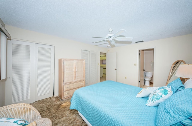 carpeted bedroom featuring multiple closets, ceiling fan, ensuite bath, and a textured ceiling