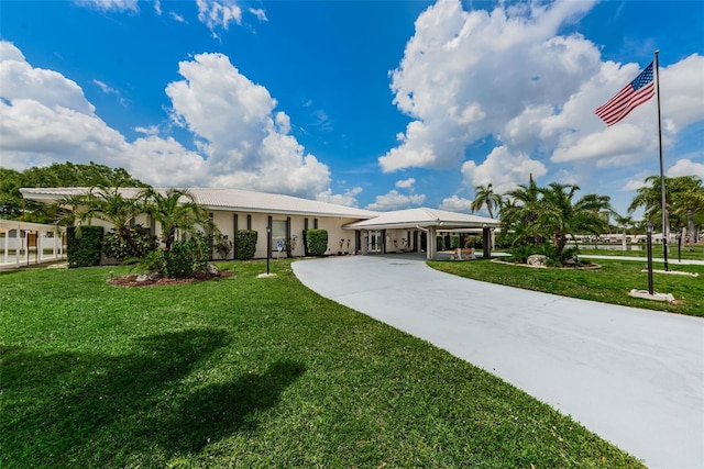 view of front of home with a front yard, driveway, and stucco siding