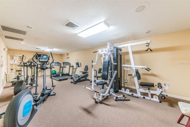 workout area with baseboards, visible vents, and a textured ceiling