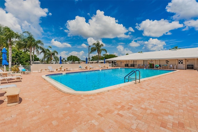 community pool featuring central AC unit, a patio area, and fence