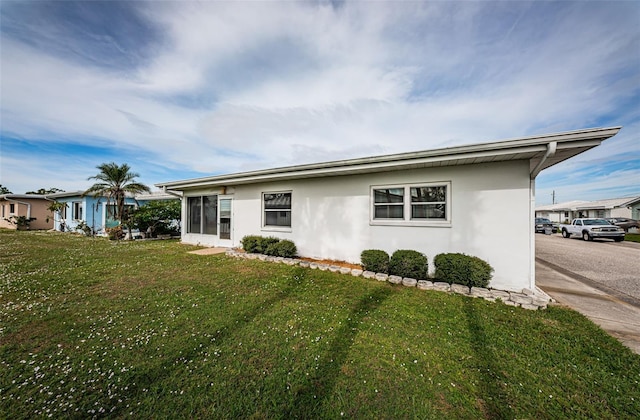 exterior space with a lawn and stucco siding