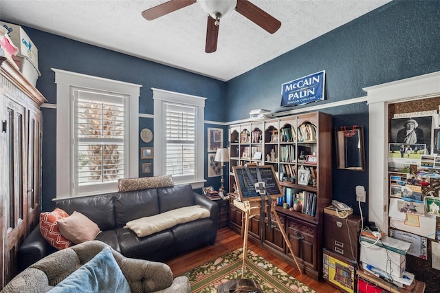 living room with a textured ceiling and dark wood-type flooring