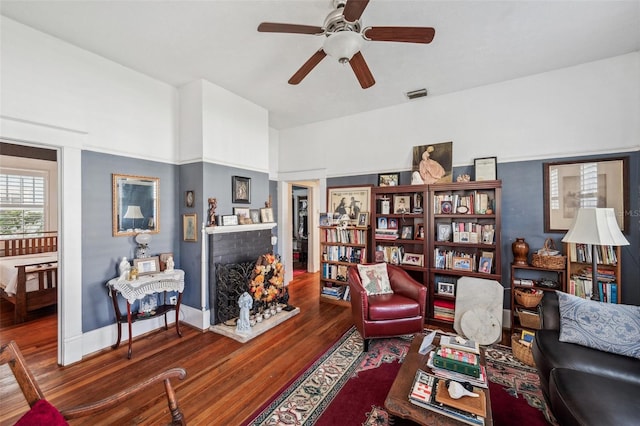 living room featuring a fireplace, dark hardwood / wood-style floors, and ceiling fan