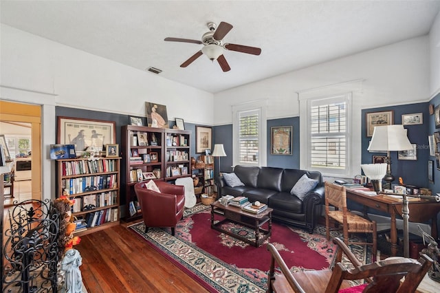 living room with ceiling fan and dark wood-type flooring