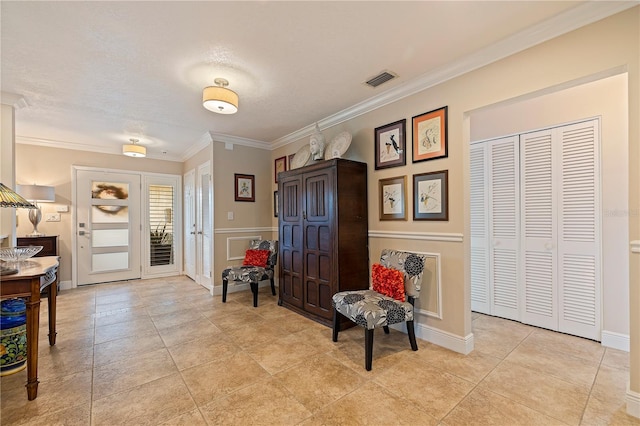 entryway with light tile patterned floors, a textured ceiling, and crown molding