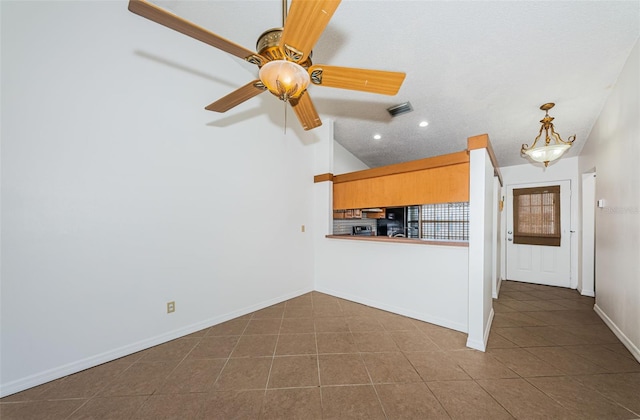 kitchen with dark tile patterned flooring, ceiling fan, and vaulted ceiling