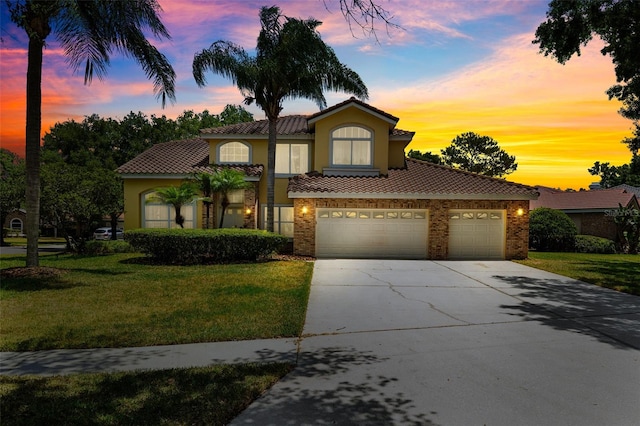 mediterranean / spanish-style home with a lawn and a garage