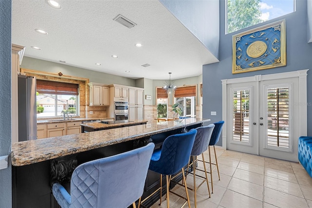 kitchen with decorative light fixtures, a healthy amount of sunlight, french doors, and tasteful backsplash