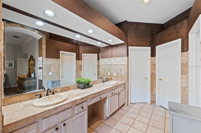 bathroom with vanity, tile patterned floors, tile walls, and ornamental molding