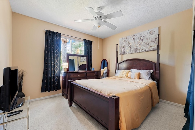 carpeted bedroom featuring ceiling fan and a textured ceiling