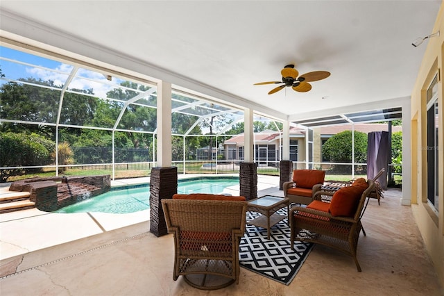 view of swimming pool with glass enclosure, ceiling fan, an outdoor living space, pool water feature, and a patio