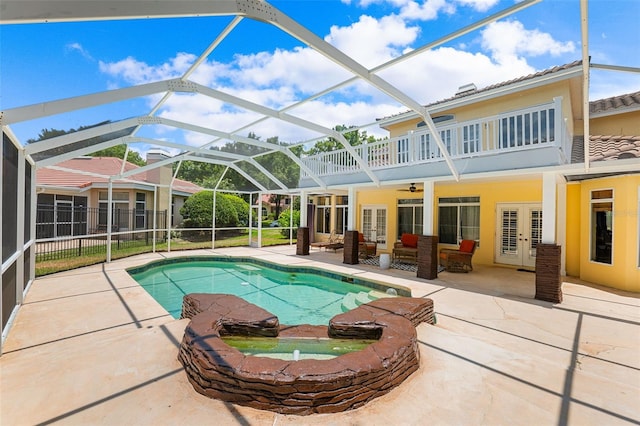 view of swimming pool with french doors, a lanai, outdoor lounge area, ceiling fan, and a patio area