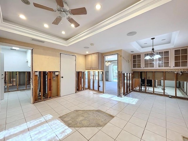 unfurnished room with ceiling fan with notable chandelier, light tile patterned floors, crown molding, and a tray ceiling