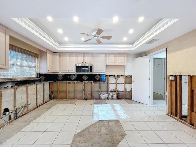 kitchen with ceiling fan, decorative backsplash, crown molding, and a tray ceiling