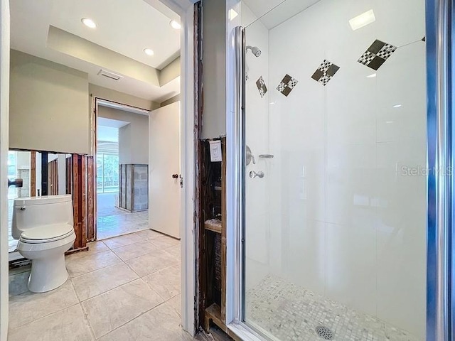 bathroom featuring tiled shower, tile patterned floors, and toilet