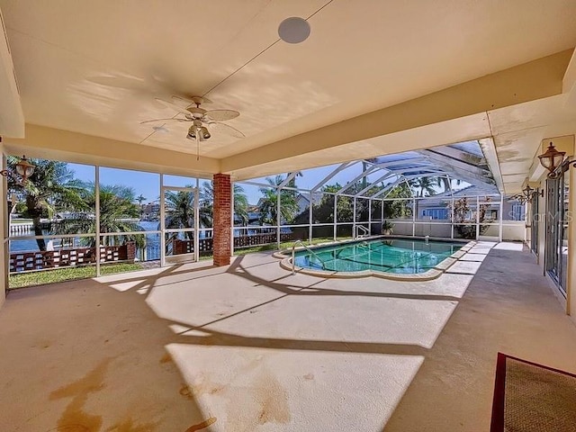 view of swimming pool with glass enclosure, ceiling fan, and a patio area