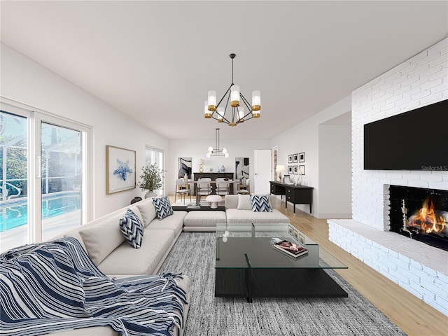 living room with a fireplace, an inviting chandelier, and hardwood / wood-style flooring