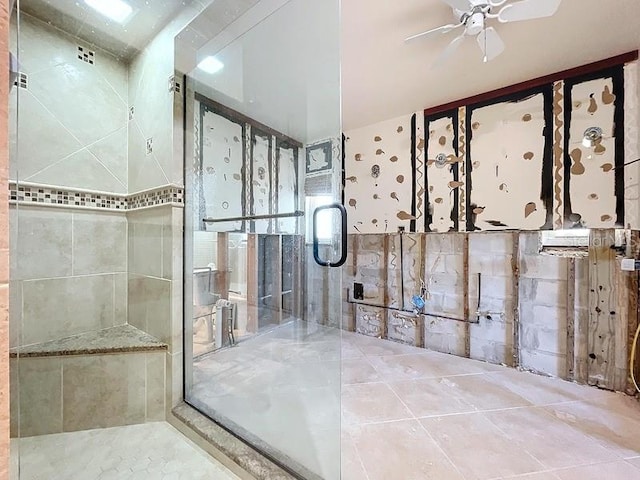 bathroom with tile patterned floors, ceiling fan, and a shower with shower door