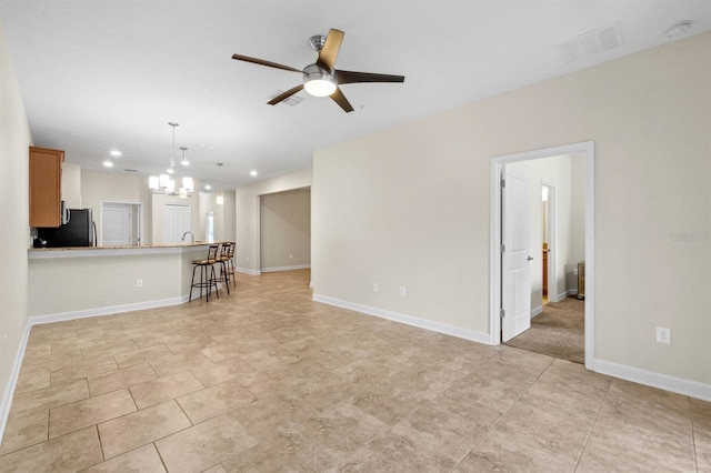 living room with ceiling fan with notable chandelier