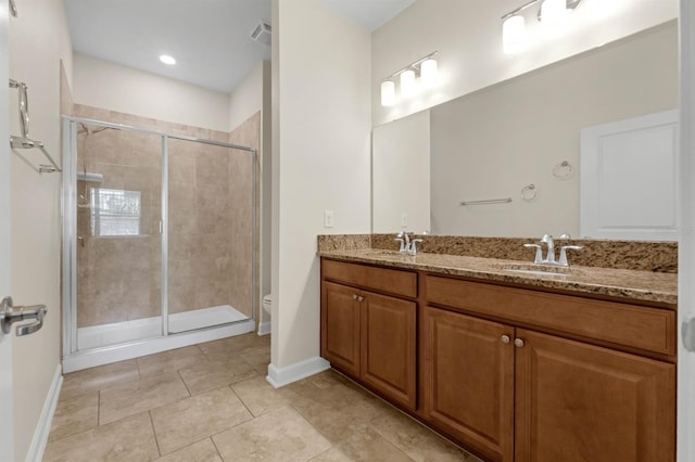 bathroom with an enclosed shower, vanity, toilet, and tile patterned floors