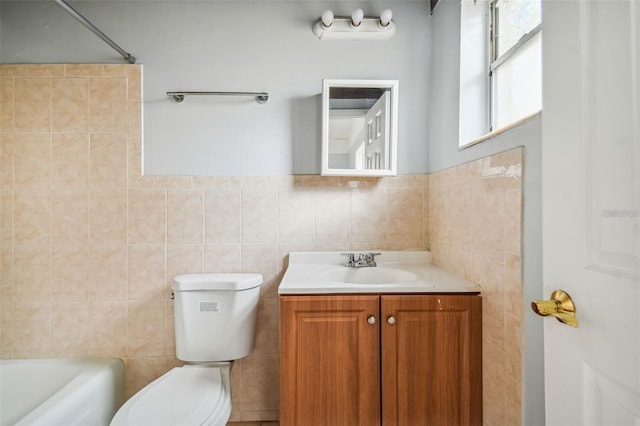 bathroom featuring vanity, toilet, and tile walls