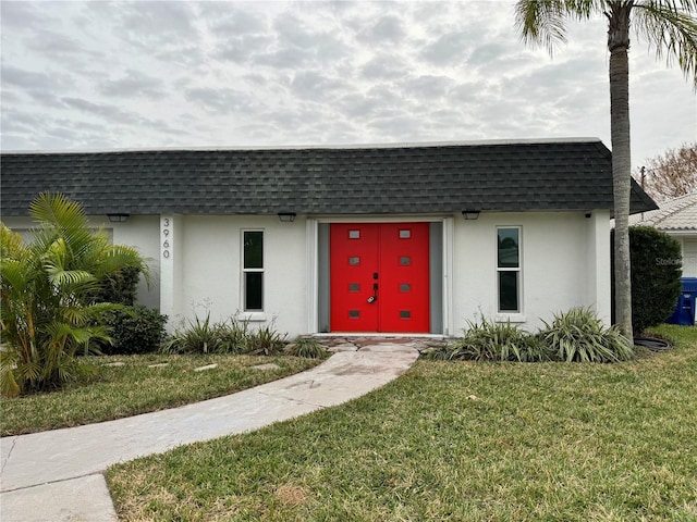 3960 Headsail Dr, New Port Richey, FL 34652 - view of front of house featuring roof with shingles, mansard roof, and stucco siding