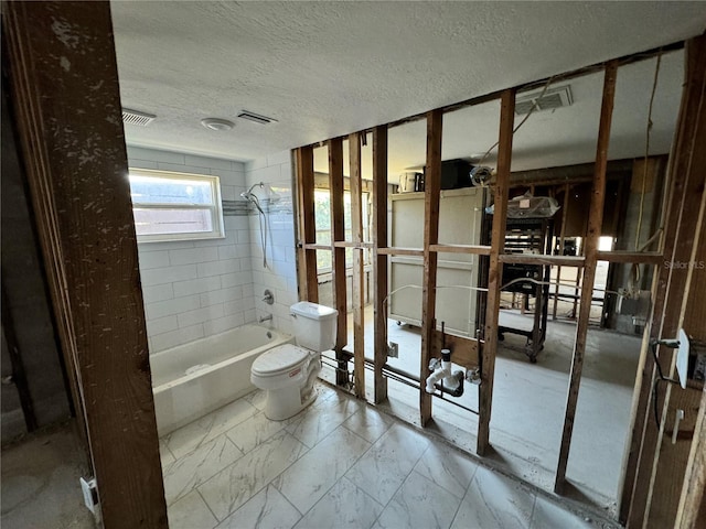 bathroom featuring a textured ceiling,  shower combination, and toilet