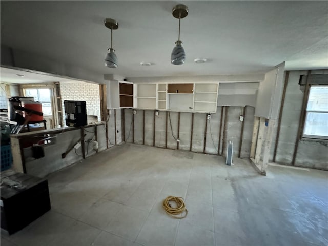 basement with a wood stove and a wealth of natural light