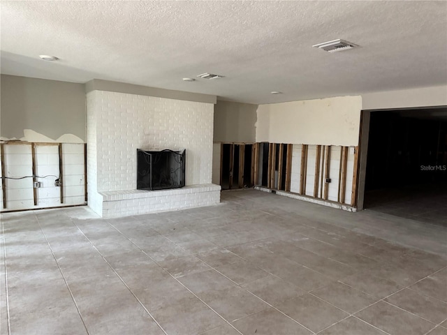 3960 Headsail Dr, New Port Richey, FL 34652 - unfurnished living room featuring a textured ceiling, a fireplace, and tile patterned floors