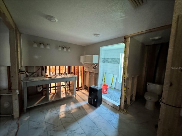 3960 Headsail Dr, New Port Richey, FL 34652 - bathroom featuring toilet, marble finish flooring, vanity, and a textured ceiling
