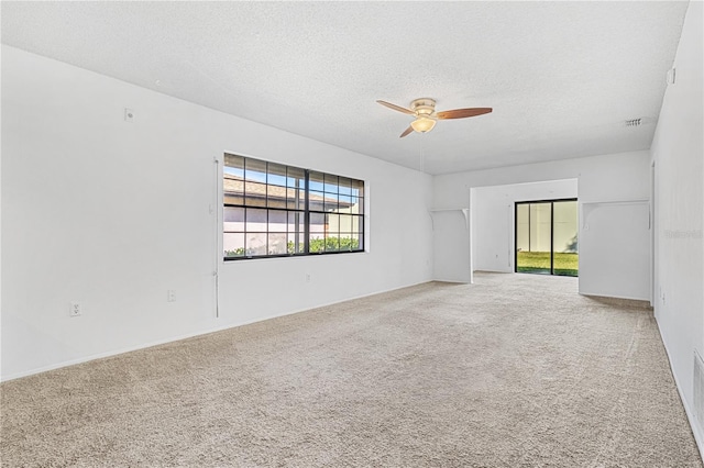 carpeted empty room featuring ceiling fan and a textured ceiling