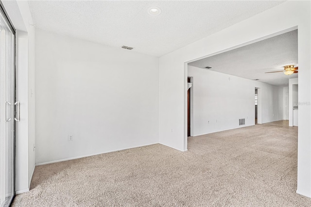 spare room with carpet flooring, a textured ceiling, and ceiling fan