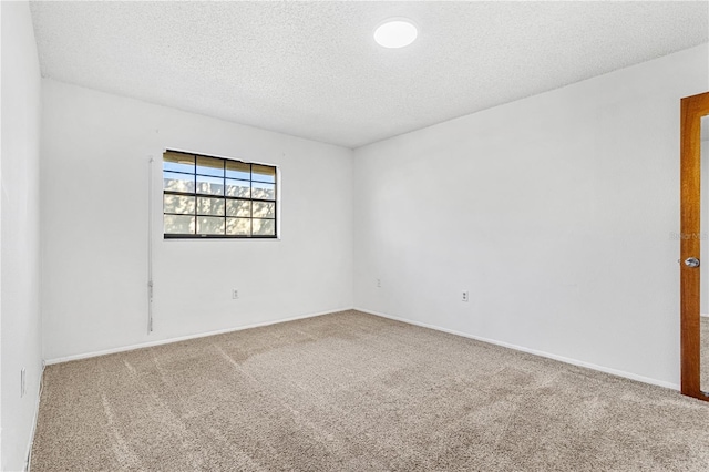 carpeted empty room with a textured ceiling