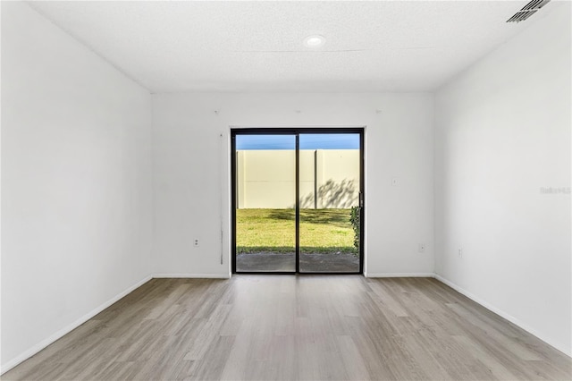 unfurnished room with light wood-type flooring, baseboards, and visible vents