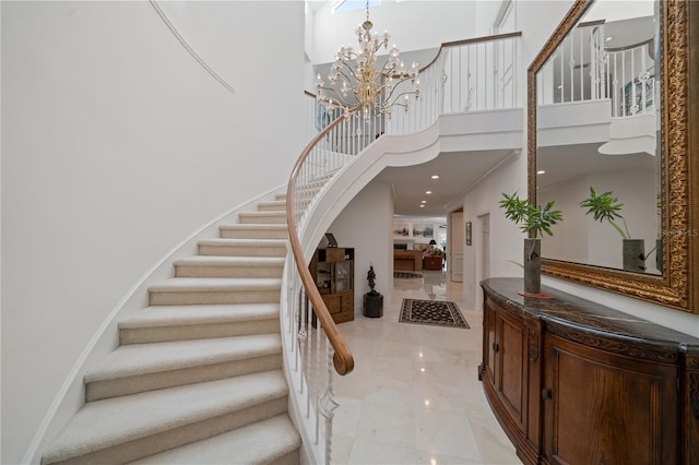 staircase featuring crown molding, a high ceiling, and an inviting chandelier