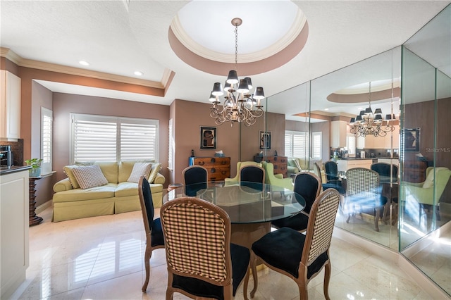 dining space featuring a raised ceiling, a wealth of natural light, and a notable chandelier