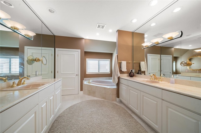 bathroom featuring tile patterned floors, vanity, and a relaxing tiled tub