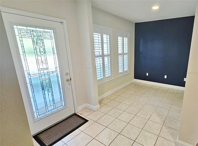 foyer entrance featuring light tile patterned floors and a healthy amount of sunlight