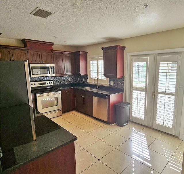 kitchen featuring tasteful backsplash, stainless steel appliances, plenty of natural light, and sink