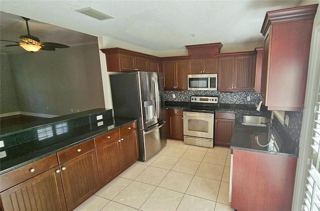 kitchen featuring sink, ceiling fan, tasteful backsplash, light tile patterned flooring, and stainless steel appliances