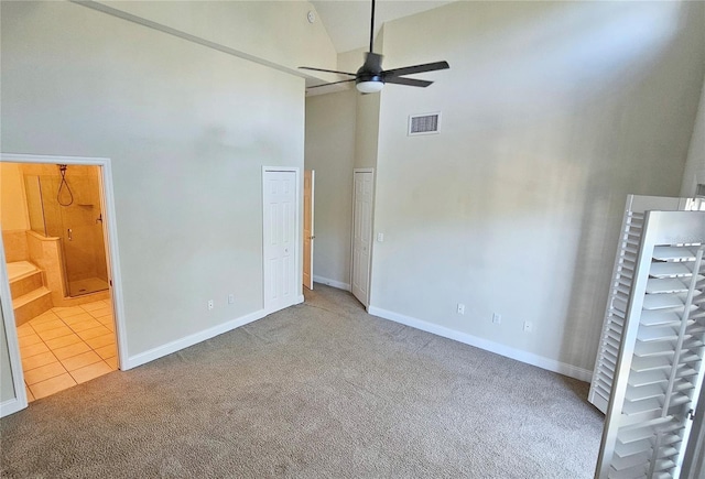 unfurnished bedroom featuring carpet floors, ceiling fan, and high vaulted ceiling