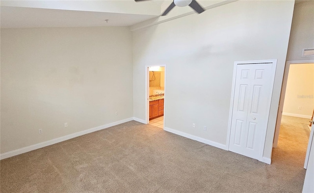 unfurnished bedroom featuring ceiling fan, high vaulted ceiling, and light carpet