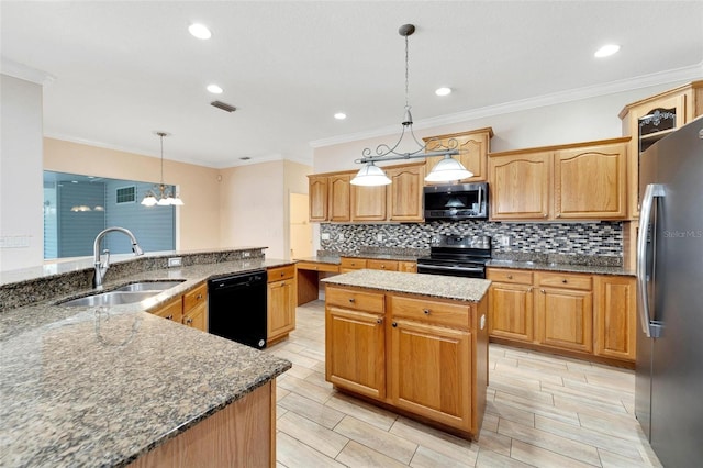 kitchen featuring appliances with stainless steel finishes, dark stone counters, sink, decorative light fixtures, and a kitchen island