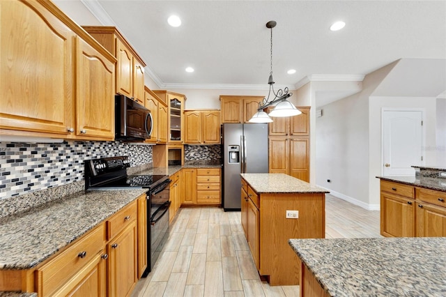 kitchen with black appliances, a kitchen island, light stone counters, and ornamental molding