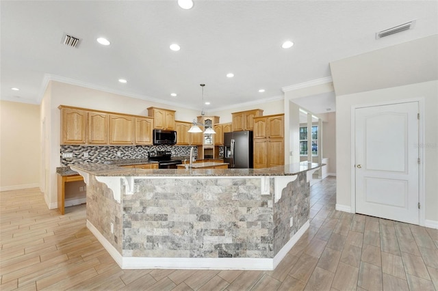 11305 Sweet Bay Ct, Riverview, FL 33569 - kitchen with black appliances, a large island, tasteful backsplash, a breakfast bar, and light stone counters