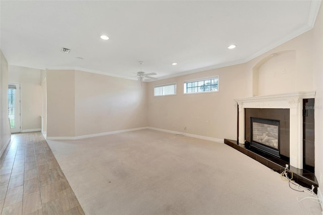 unfurnished living room with a fireplace, ceiling fan, and crown molding