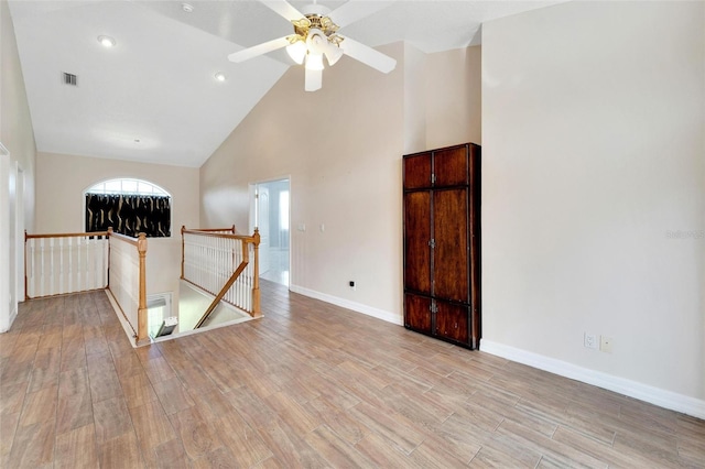 unfurnished room with ceiling fan, high vaulted ceiling, and light hardwood / wood-style flooring