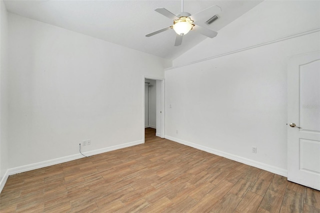 spare room featuring light wood-type flooring, vaulted ceiling, and ceiling fan