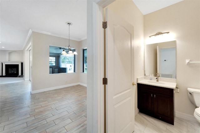 bathroom with vanity, crown molding, an inviting chandelier, and toilet